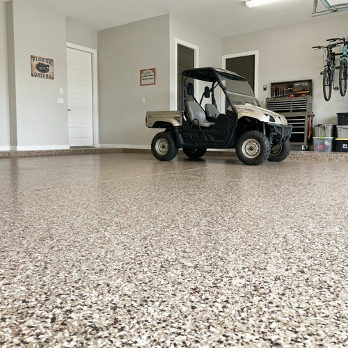 Garage with a golf cart on a speckled epoxy flake floor, tools, and bicycles in the background.